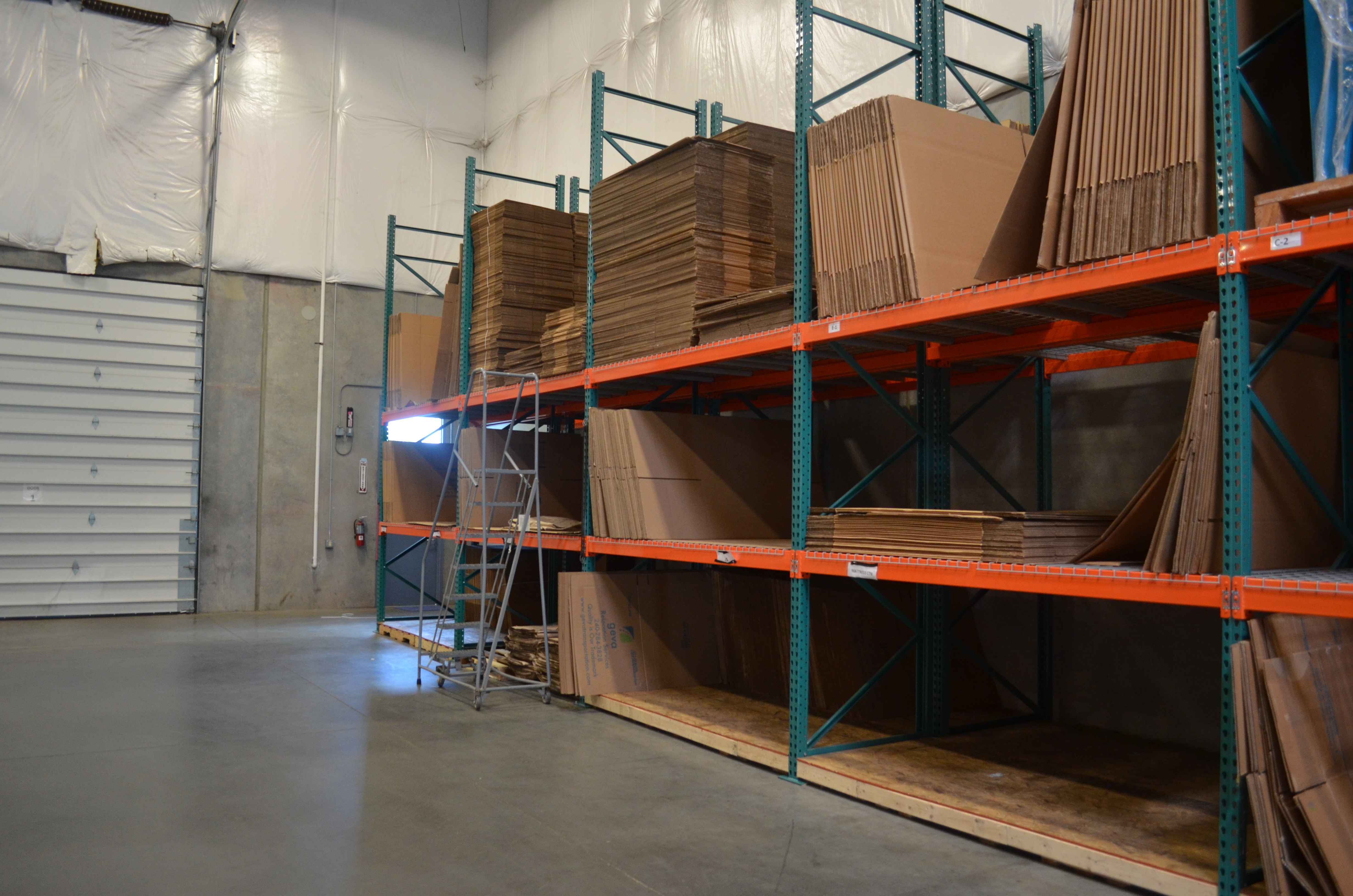 Unassembled Geva cardboard boxes on warehouse shelves